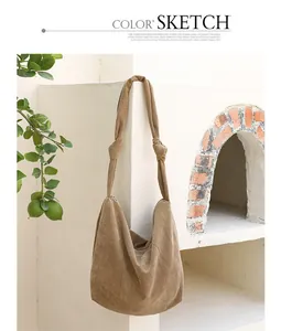 Casual khaki corduroy shoulder bag with knotted straps hanging against a white wall.