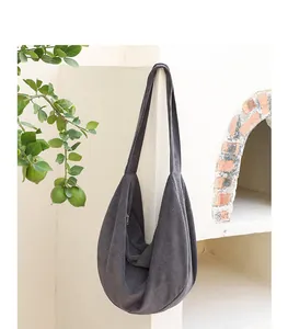 Elegante bolso bandolera gris oscuro de punto gofrado en un entorno rústico al aire libre