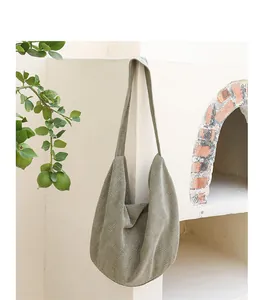 Primer plano del bolso hobo de pana verde oliva que muestra la textura de gofre.