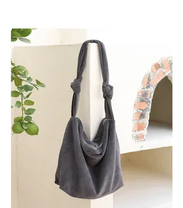 Minimalist grey corduroy hobo shoulder bag with unique knotted straps and zipper closure