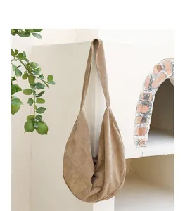 Detalle del bolso de pana caqui en un entorno minimalista de estilo de vida