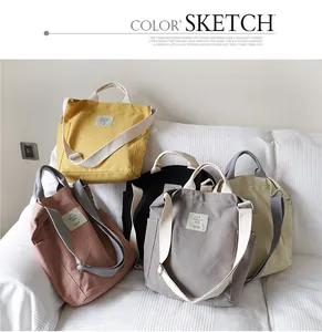 Detailed view of multiple colors of casual canvas tote bags on a white sofa background