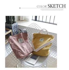 Casual canvas tote bags in pink and yellow on a white chair, minimalist Korean style.