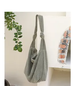Detail view of a minimalist olive green corduroy shoulder bag with knotted strap design