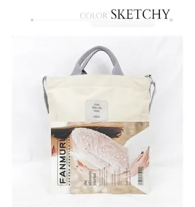 Detail view of a cream canvas tote bag with a fashion magazine for size reference