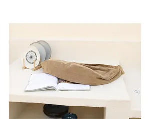 Primer plano de un bolso de pana caqui de gran capacidad en un estante blanco