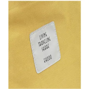 Detailed macro view of yellow canvas shoulder bag featuring living traveling share patch