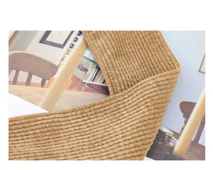 Primer plano de tela de pana marrón y costuras limpias en un bolso bandolera estilo hobo.