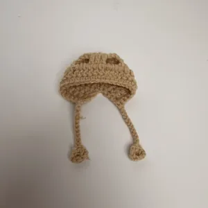 Detailed view of handmade khaki knitted mini hat for dolls featuring straps and ties