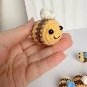 Close-up of hand-crocheted bee keychain accessory with soft yarn texture and cute design