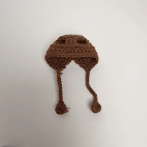 Detailed view of a handmade brown crochet mini hat with ear flaps for doll accessories