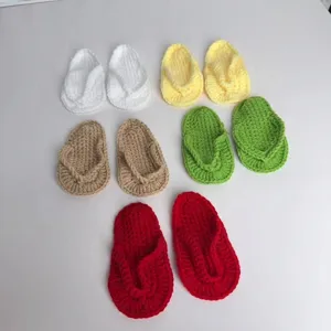 Nahaufnahme von bunten handgestrickten Baby-Flip-Flops für die Neugeborenen-Fotografie