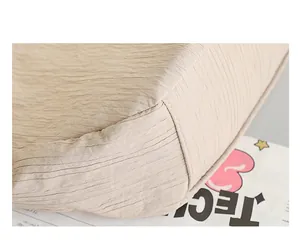 Close-up of the pleated fabric and neat stitching on a beige nylon shoulder bag.