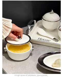 Dettaglio di un set da colazione di lusso in ceramica bianca con bordo argento e ciotola