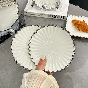 Elegantes Set aus weißen Keramik-Desserttellern mit silbernem Wellenrand und Sonnenstrahlmuster