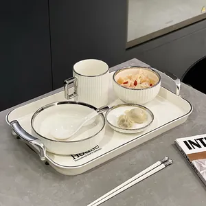 Elegante set di stoviglie per la colazione in ceramica bianca con bordo argento e vassoio