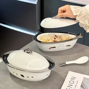 Pratique plat chauffant en céramique en forme de poisson avec couvercle et cuillère.