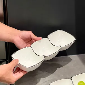 Minimalist white ceramic three-compartment appetizer bowl with elegant silver rim detailing