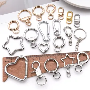 Variety of gold and silver metal keychain hooks and lobster clasps with measurement ruler