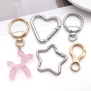 Close-up of DIY keychain hardware featuring heart and star-shaped metal clips with a balloon dog