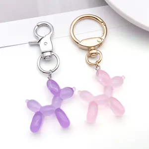 Close-up of cute purple and pink balloon dog keychains with metal clasps