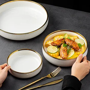 Service d'assiettes creuses en céramique blanche de luxe avec bord doré et texture côtelée