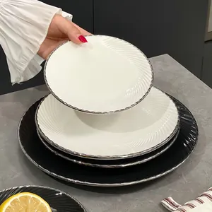 Élégante assiette en céramique blanche avec motif spirale et bord argenté pour steak