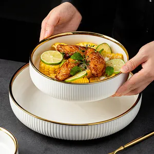 Assiette creuse élégante en céramique blanche avec bord doré et texture nervurée