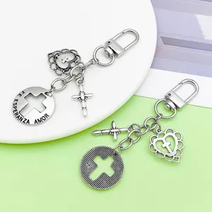 Detaillierte Nahaufnahme antiker silberner Kreuz- und Herzanhänger an einem Schlüsselbund.