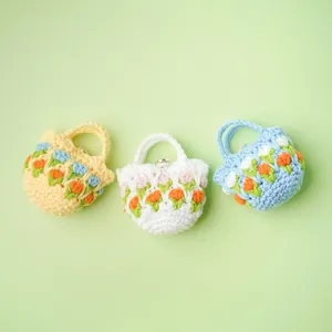 Handmade crocheted tulip flower headphone pouches in three colors on green background.