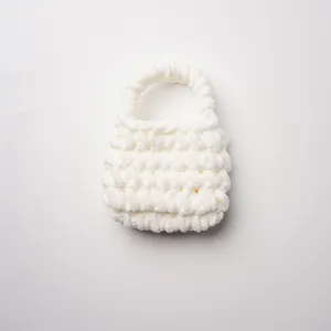 Vista detallada de un mini bolso blanco hecho a mano con suave hilo de chenilla