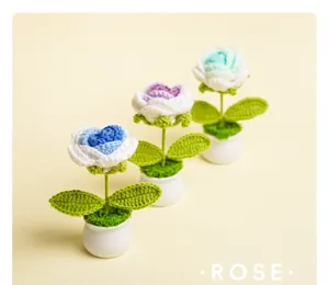 Handmade crochet rose potted plant detail, cute knitted flowers in white ceramic pots for decor.