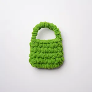 Primer plano de una mini bolsa para auriculares tejida a mano en verde brillante