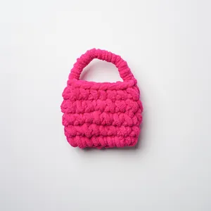 Vista detallada de un mini bolso de ganchillo hecho a mano en color rosa fucsia