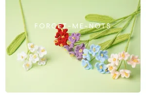 Close-up detail of colorful hand-knitted crochet forget-me-not flowers on a green background