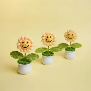 Handcrafted crochet sunflower potted plants featuring smiley faces on a soft yellow background.