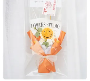 Detailweergave van handgebreid gehaakt zonnebloemboeket in een oranje luxe cadeauverpakking