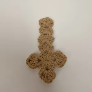 Detailopname van een handgehaakt kaki kruis met een verfijnde gebreide textuur