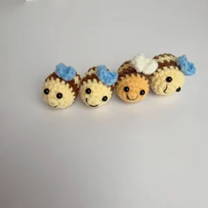 Macro view of four cute handmade crochet bee charms for keychains and gift accessories
