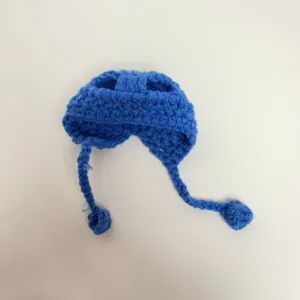 Close-up view of a blue hand-knitted crochet mini hat for dolls featuring cozy straps
