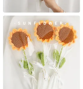 Nahaufnahme handgehäkelter Sonnenblumen in dekorativer LOVE-Geschenkfolie