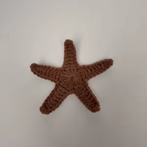Detailopname van een handgemaakte bruine gehaakte zeester met fijne gebreide textuur