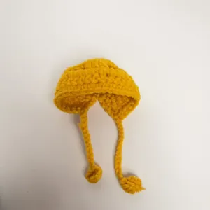Detailed view of yellow hand-knitted mini hat for plush dolls with braided chin straps