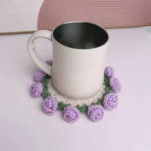 Dettaglio ravvicinato di un sottobicchiere fatto a mano all'uncinetto con rose viola