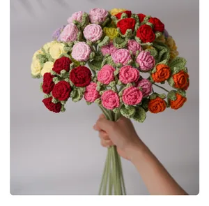 Handcrafted colorful crochet rose bouquet detail held against a grey background.