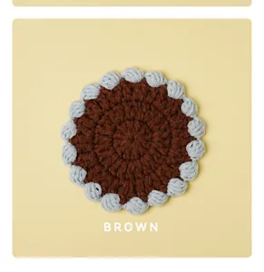 Handmade crocheted round coaster in brown and light blue color