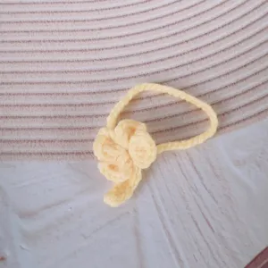 Nahaufnahme des gelben gestrickten Blumenanhängers für Plüschtiere