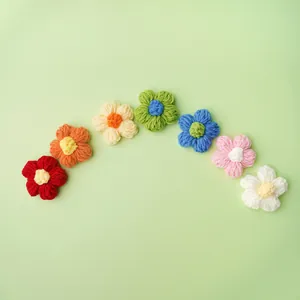 Set aus sieben bunten handgestrickten Puffblumen für Kleidung und DIY-Haarschmuck