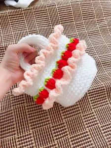 Handmade white crochet strawberry picnic basket bag featuring pink ruffled lace details
