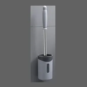 Detailopname van de aan de muur gemonteerde toiletborstel met grijze plastic houder